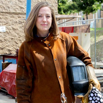 Andrea Cook holding a welding helmet