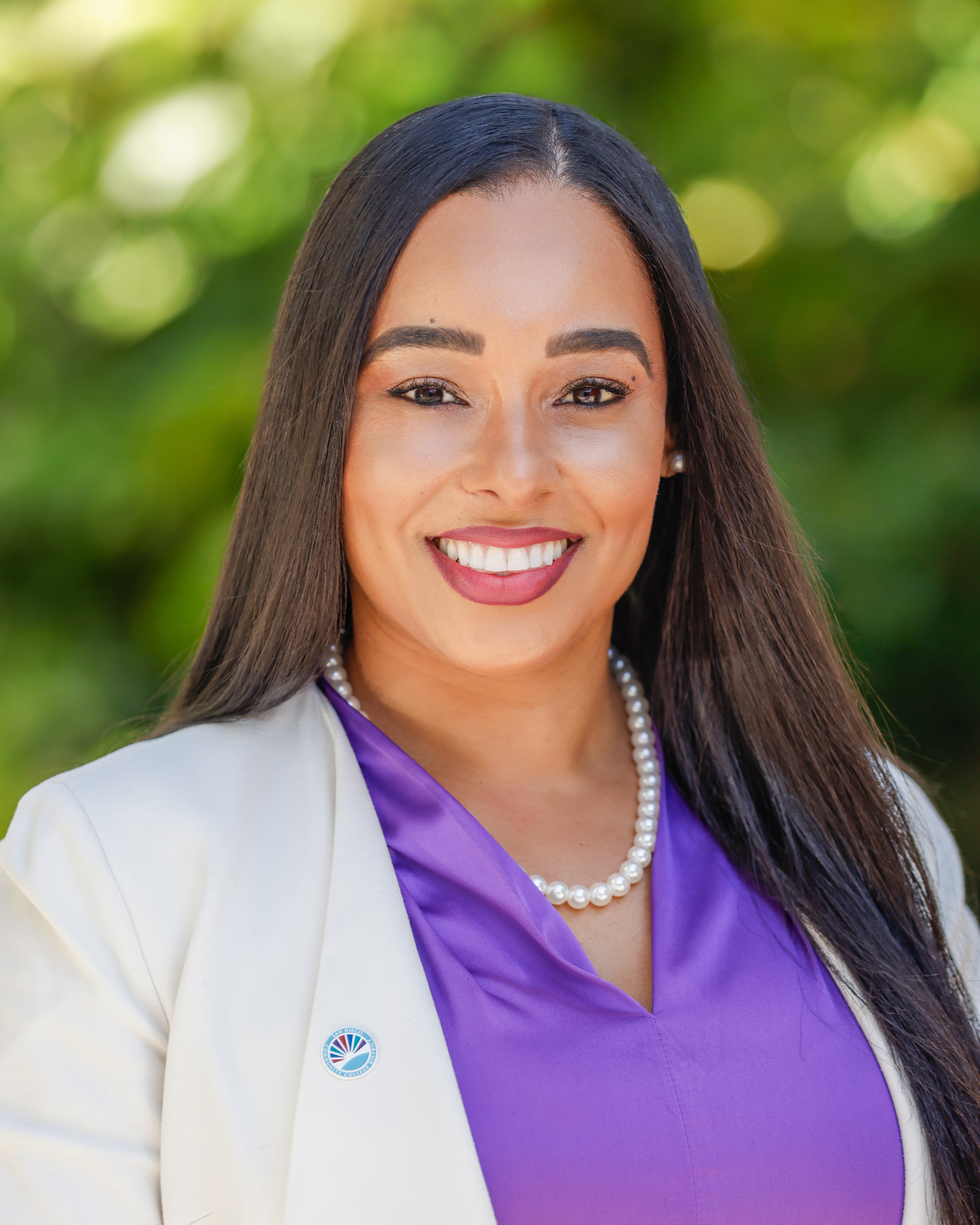 SDCCE President Tina King in a purple blouse, pearl necklace and white blazer.