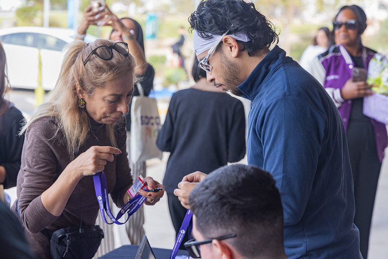 Students outside at an SDCCE event looking at lanyards